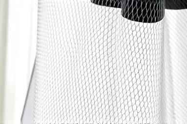 Close-up of a three-layered safety mesh on an electric mosquito swatter.