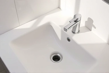 Bright, clean bathroom sink with clear drain.