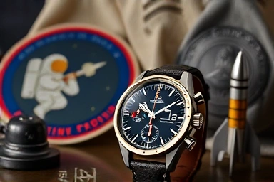 Omega Moonwatch with vintage space memorabilia, historical context