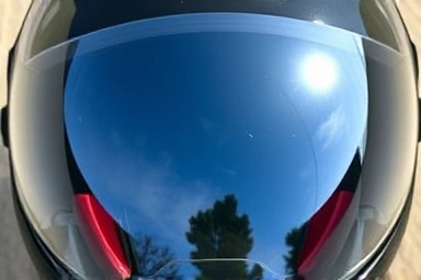 Pristine motorcycle helmet visor with protective film applied.