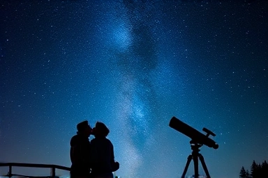 Couple stargazing at a romantic night sky.