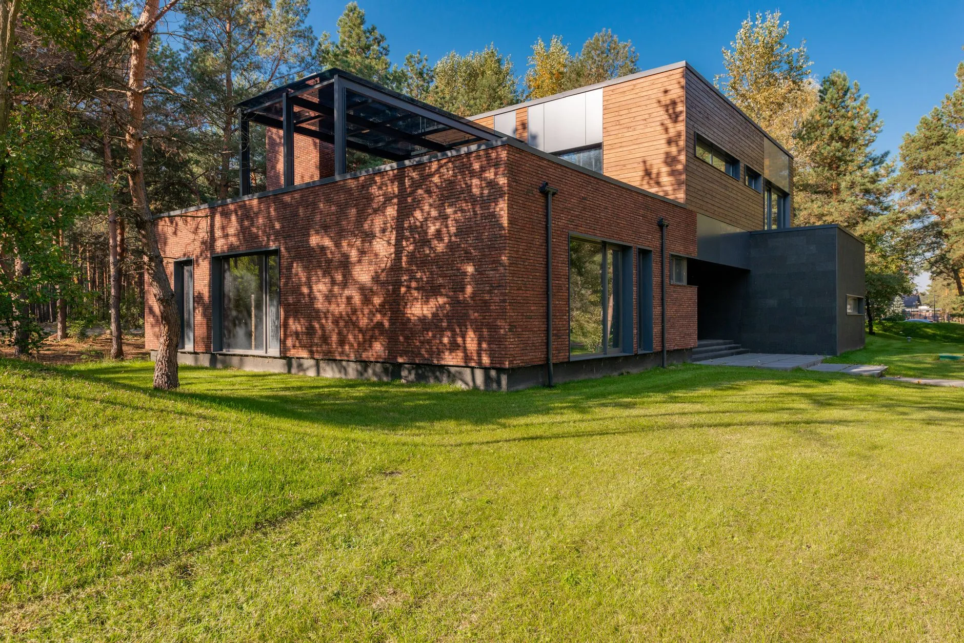 a modern prefab home exterior with clean lines and large windows in the mountains