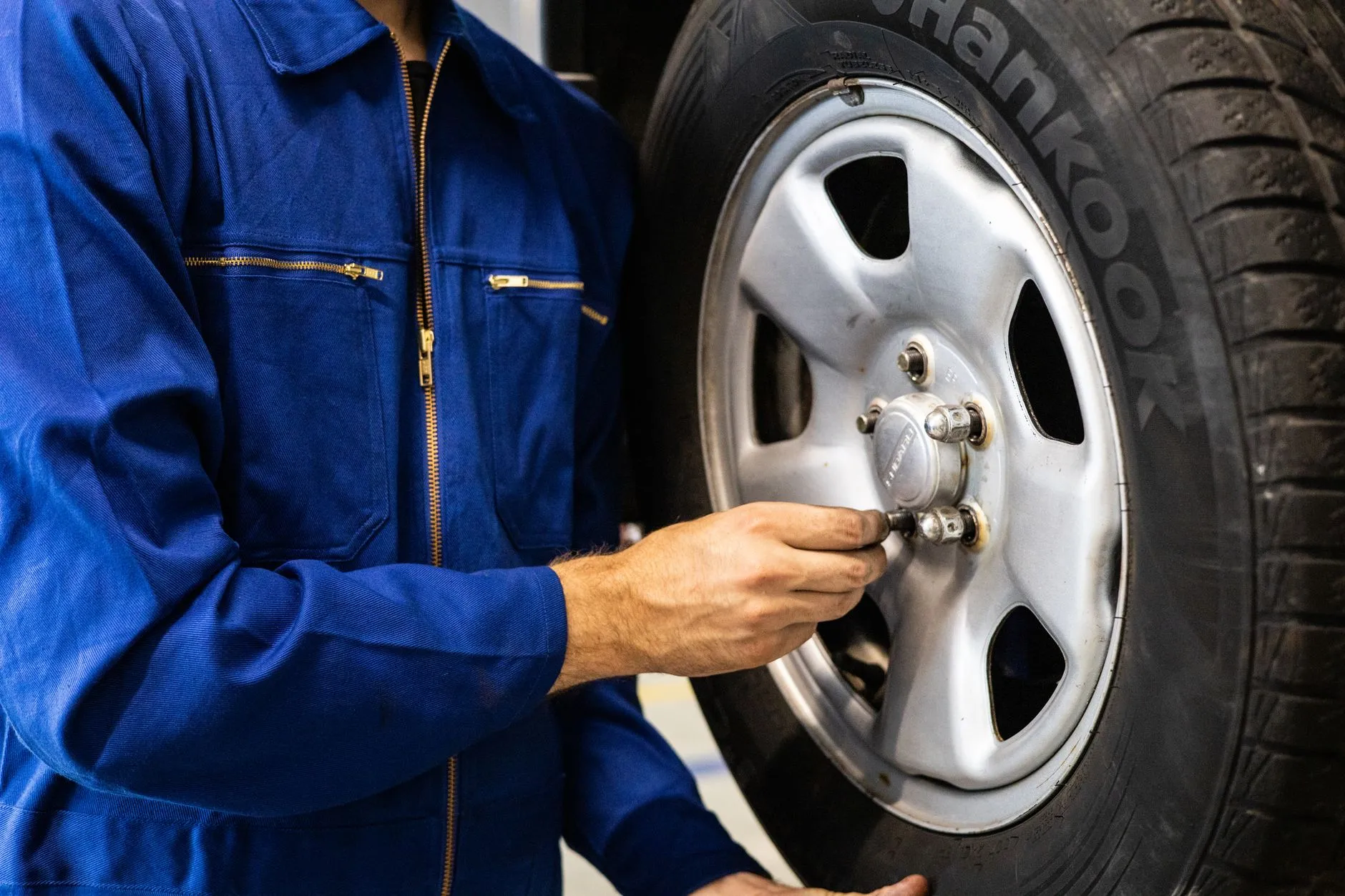 a technician inspecting a car tire for uneven wear