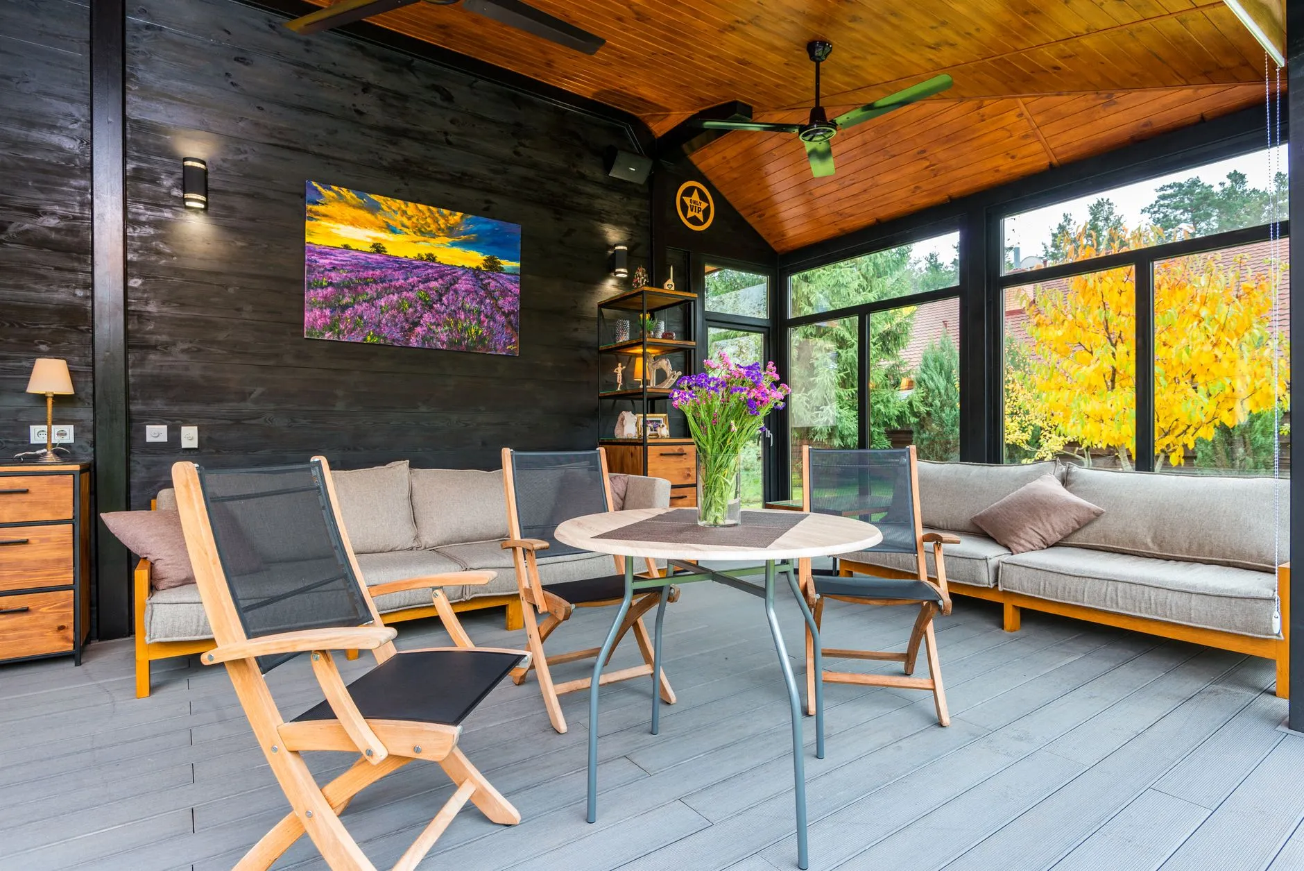 a covered porch with a timber plank ceiling and glazed walls