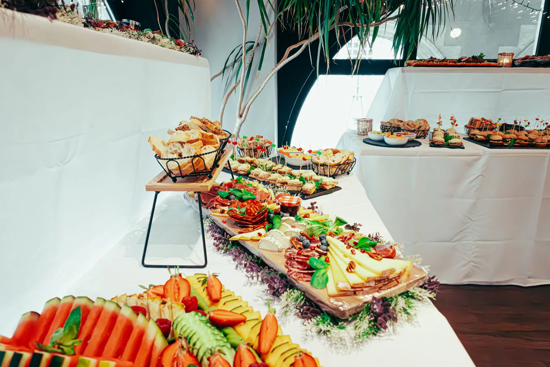 a table of party platters with sandwiches and fruit