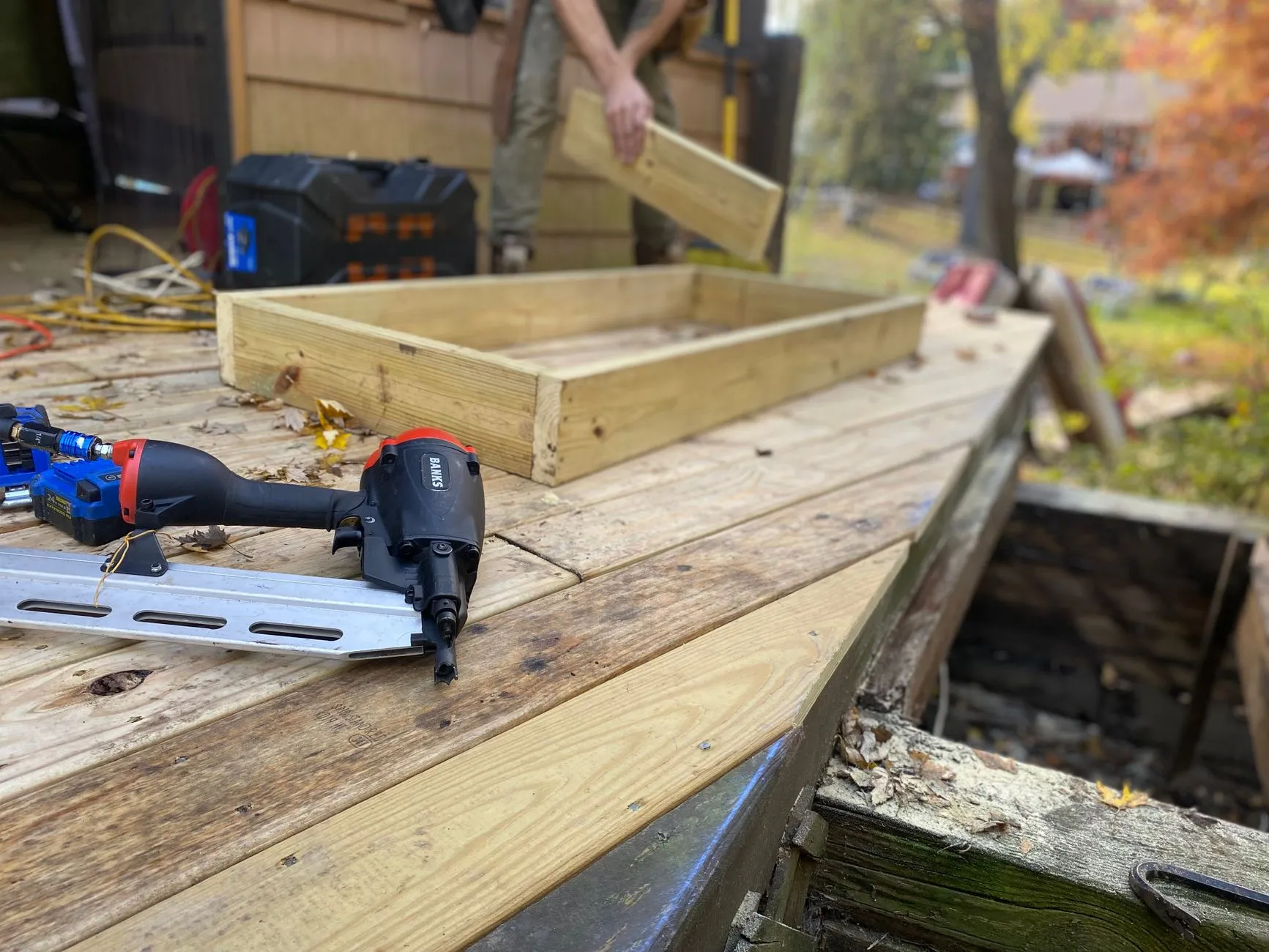 A timber deck frame being squared up on site beside an old rotted joist