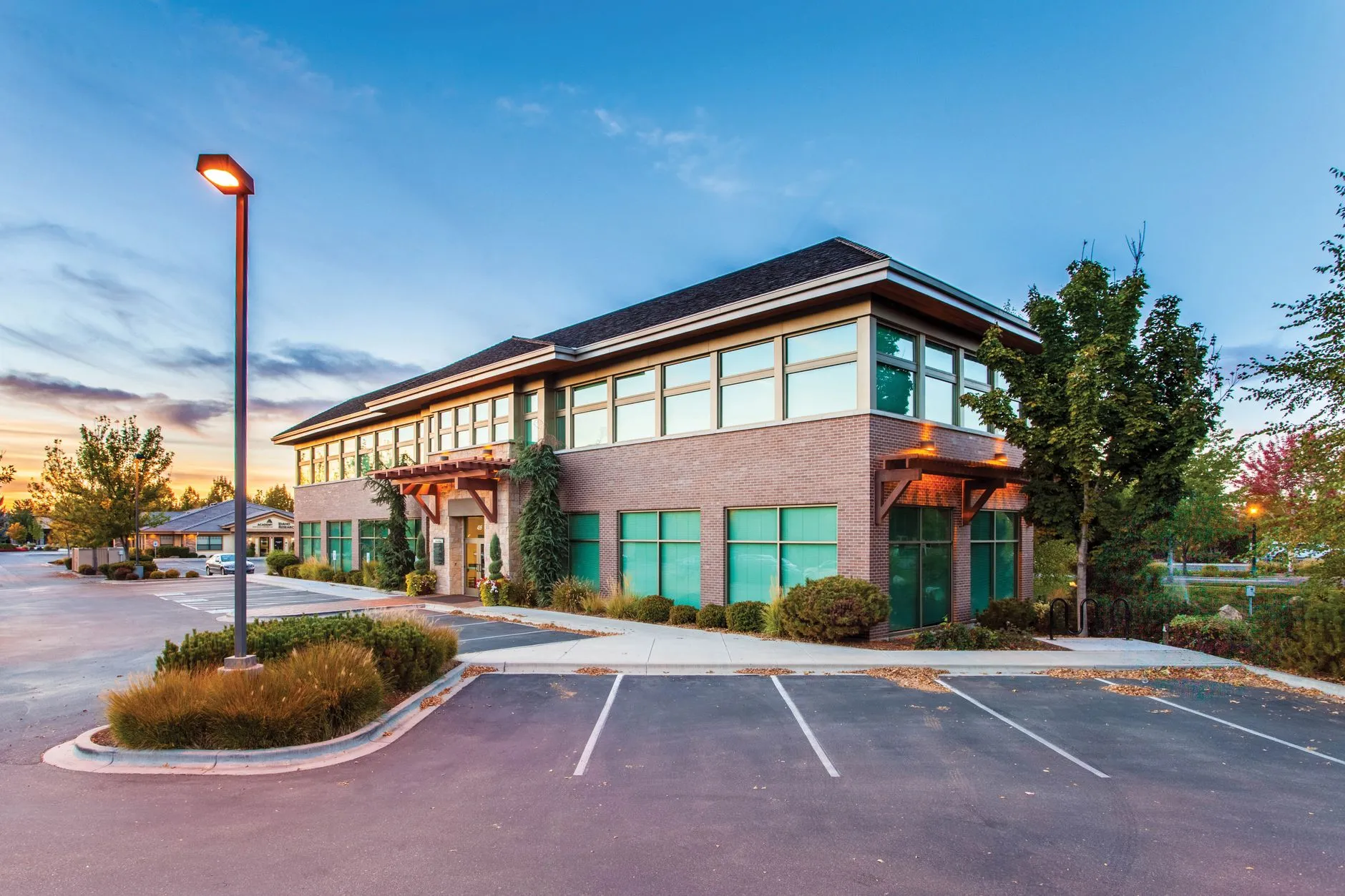 a two-storey brick and glass professional office building with parking and landscaping