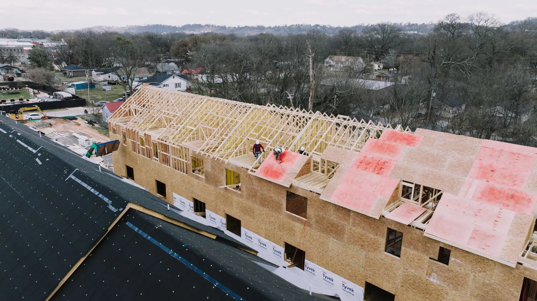 an aerial view of trusses being set along a long building frame