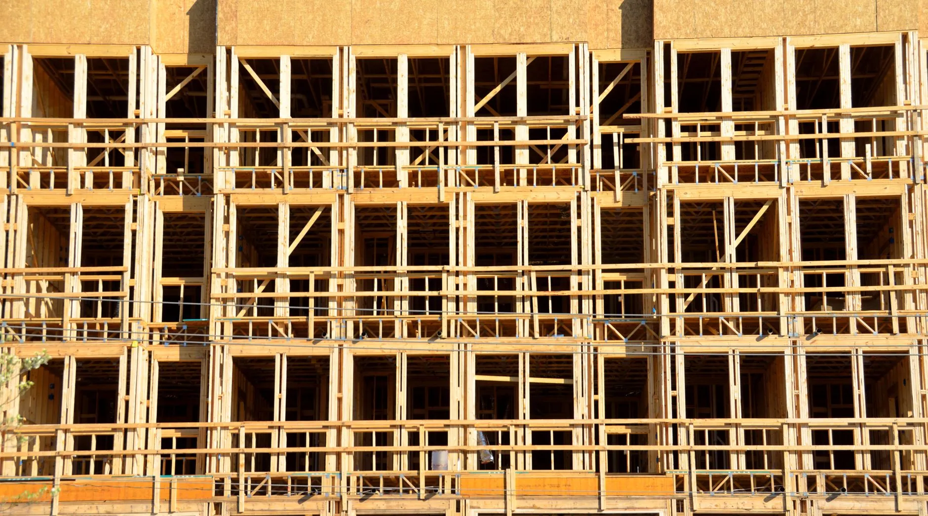 a multi-storey timber-framed apartment building with rows of window bays