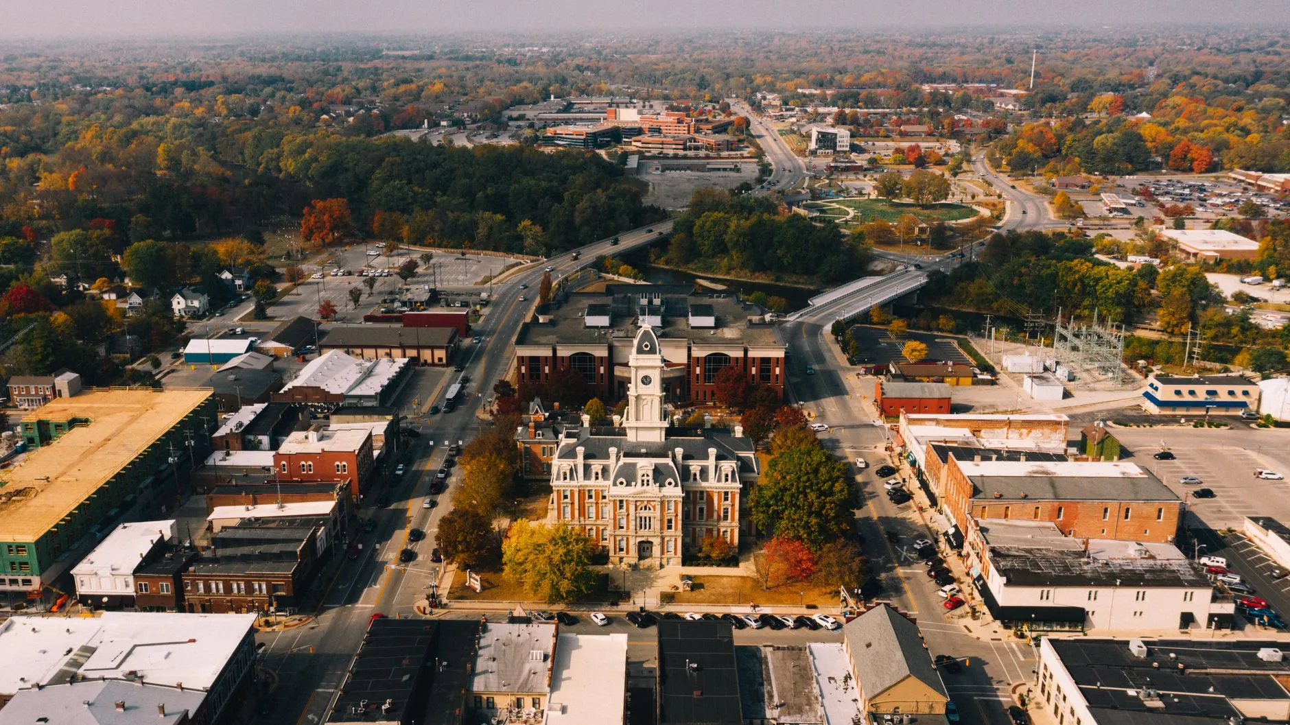 an aerial view of a small-town courthouse square and the tree-lined streets around it in autumn