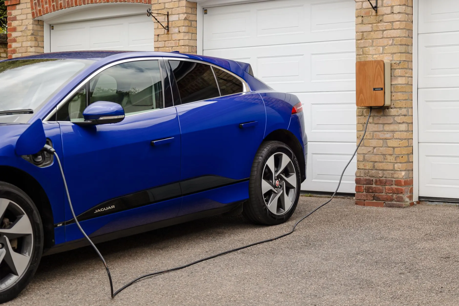 an electric car charging in a home driveway
