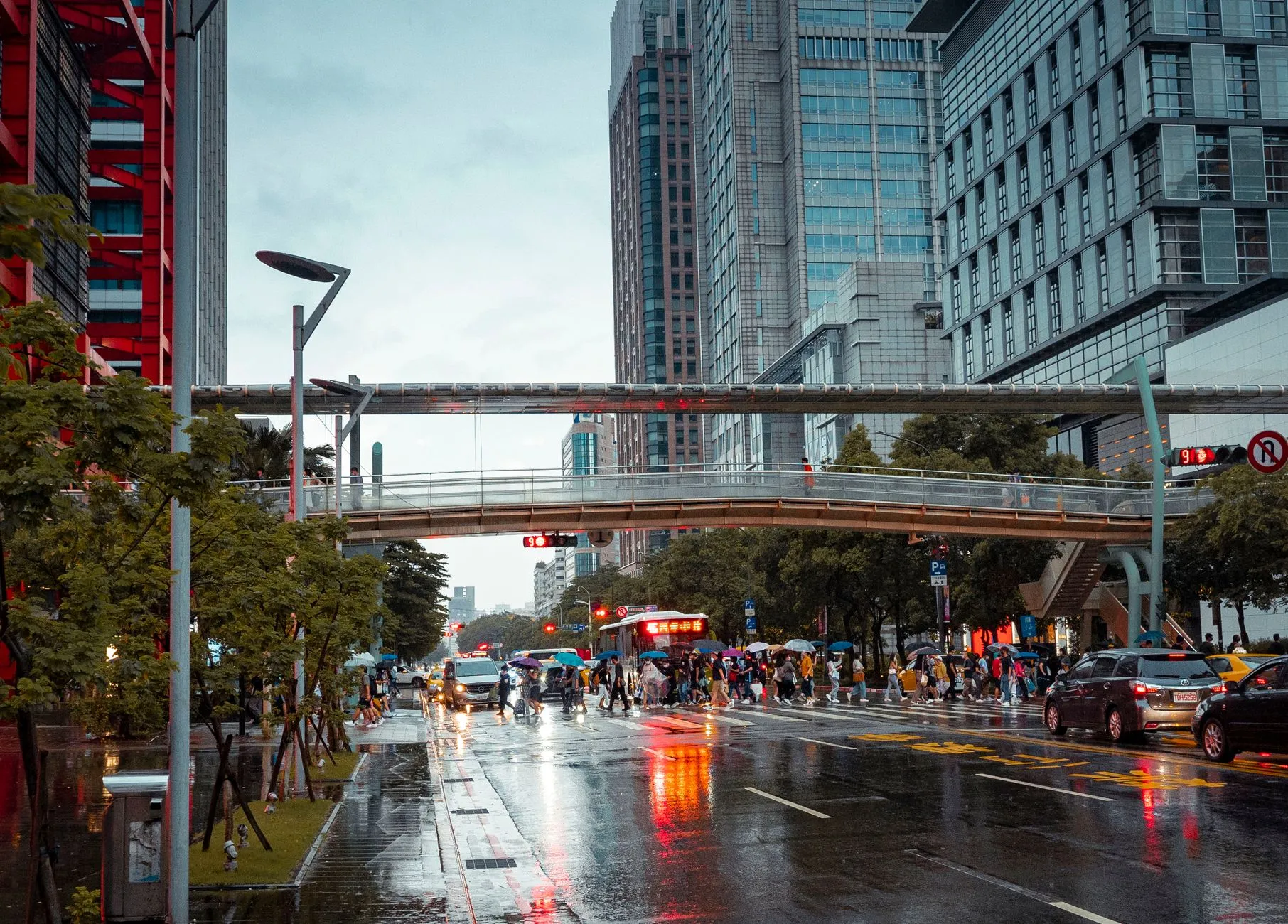 a rainy city street with tall glass buildings