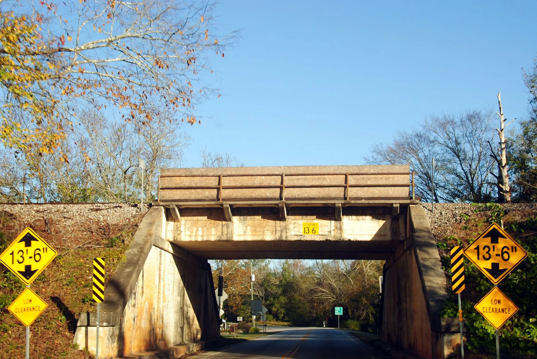 a rural overpass bridge with yellow warning signs