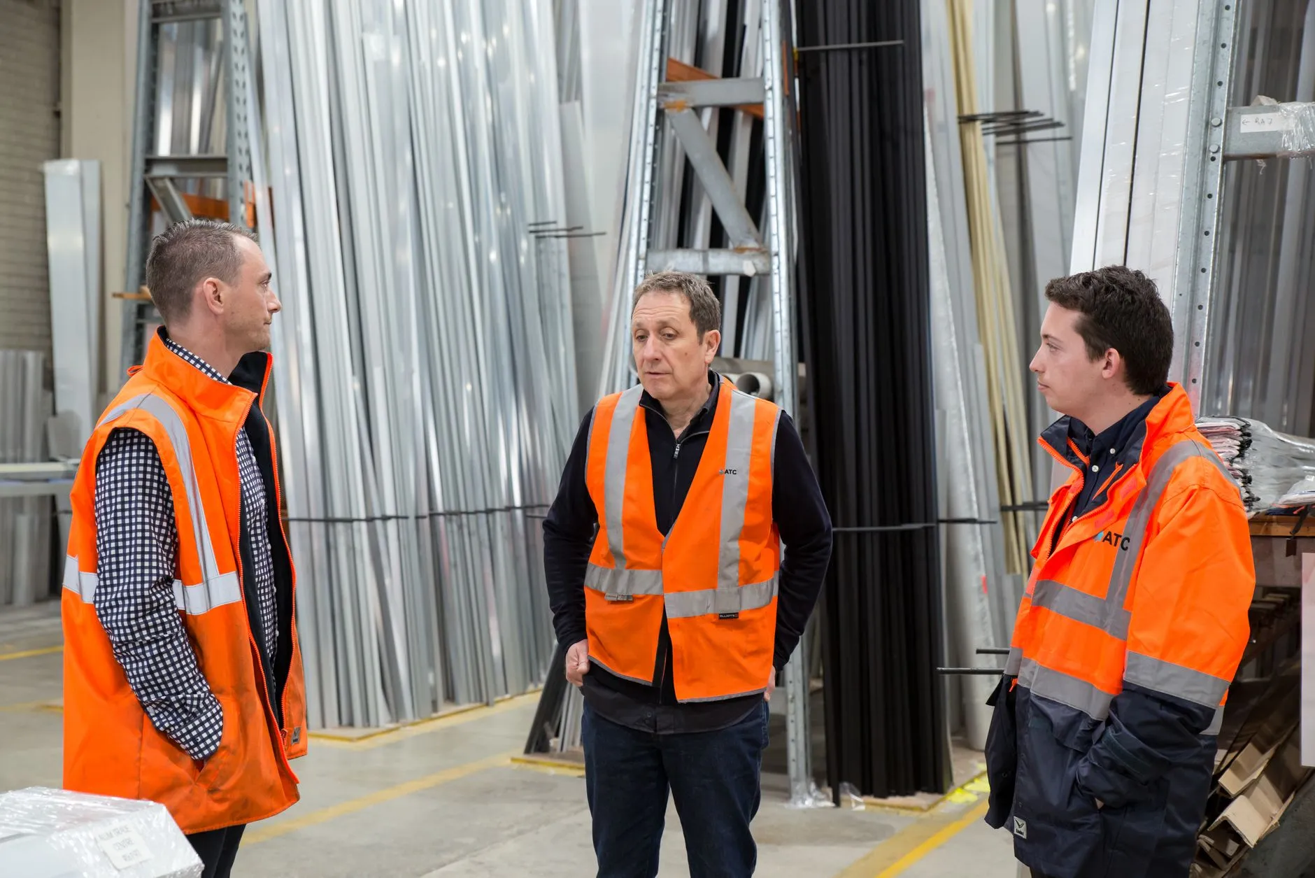 engineers in safety vests walking through a factory
