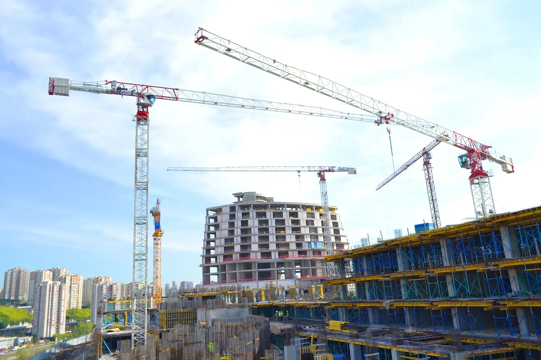 tower cranes over a concrete building under construction