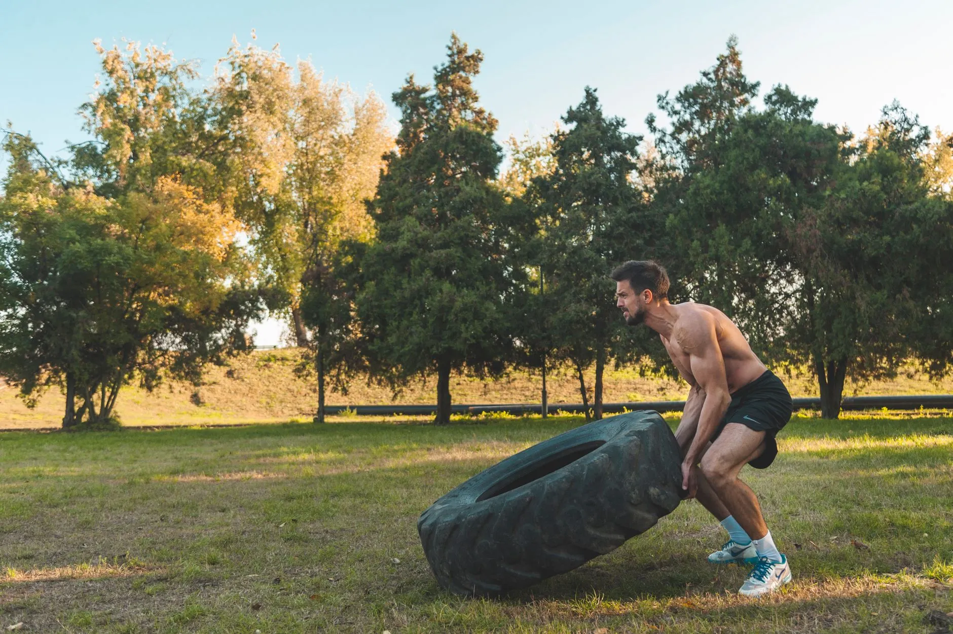 athletes flipping a heavy training tire at an outdoor bootcamp
