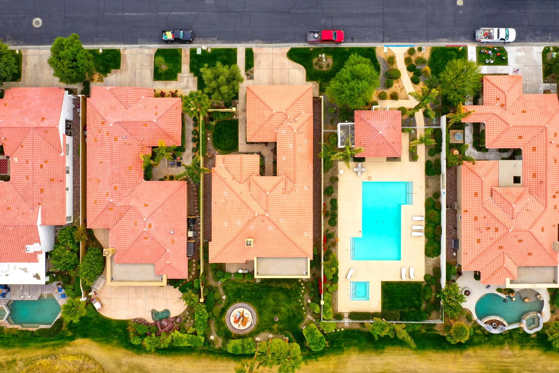 aerial view of tile-roofed homes with backyard pools