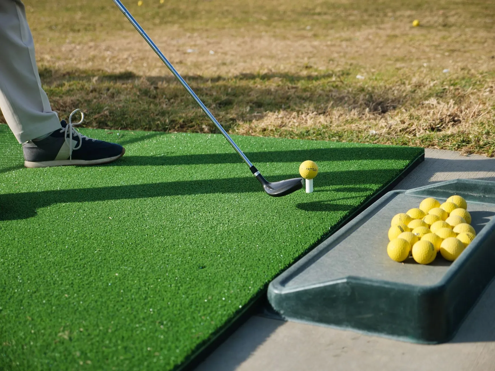 a golfer on a driving range hitting balls