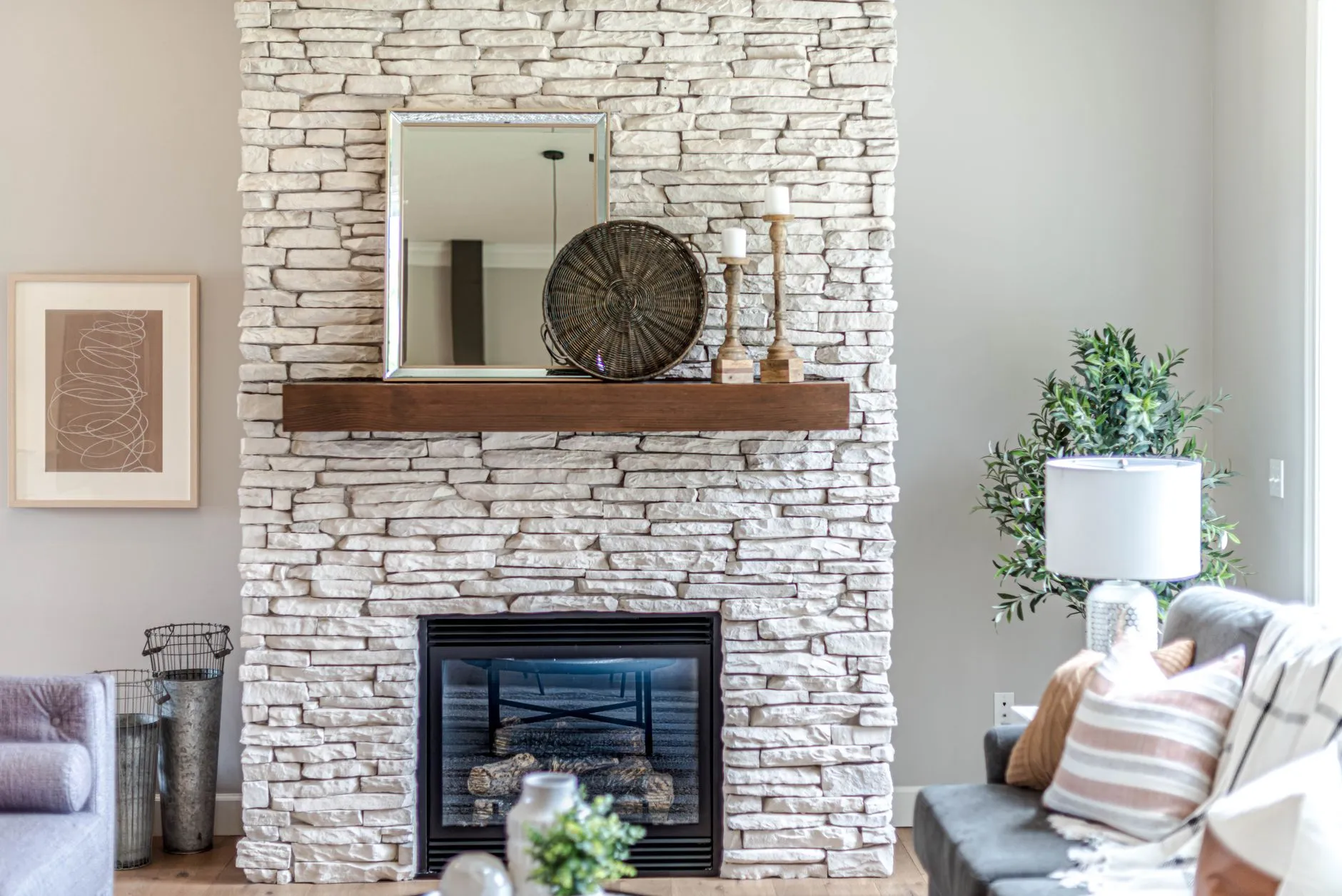 Stacked pale stone fireplace with a timber mantel shelf