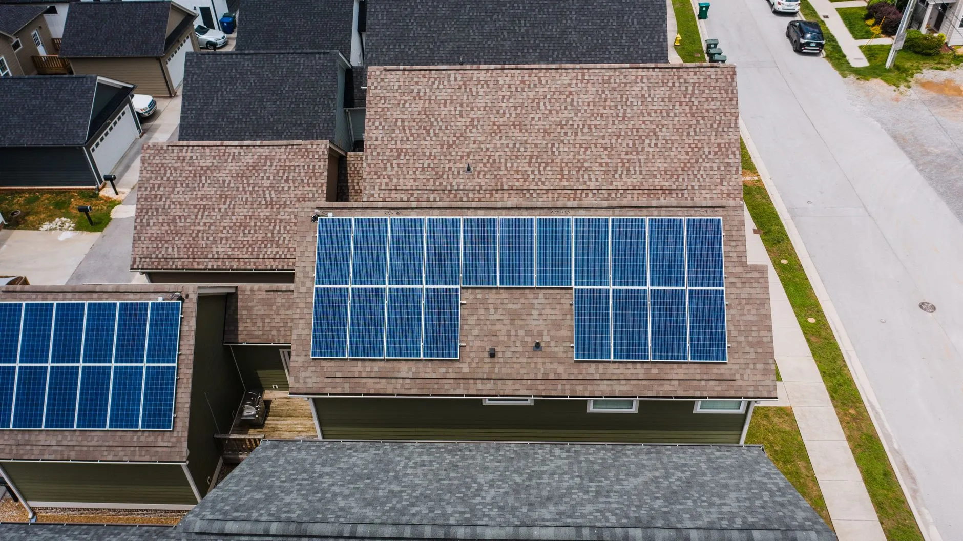 a drone view of suburban roofs with solar panels