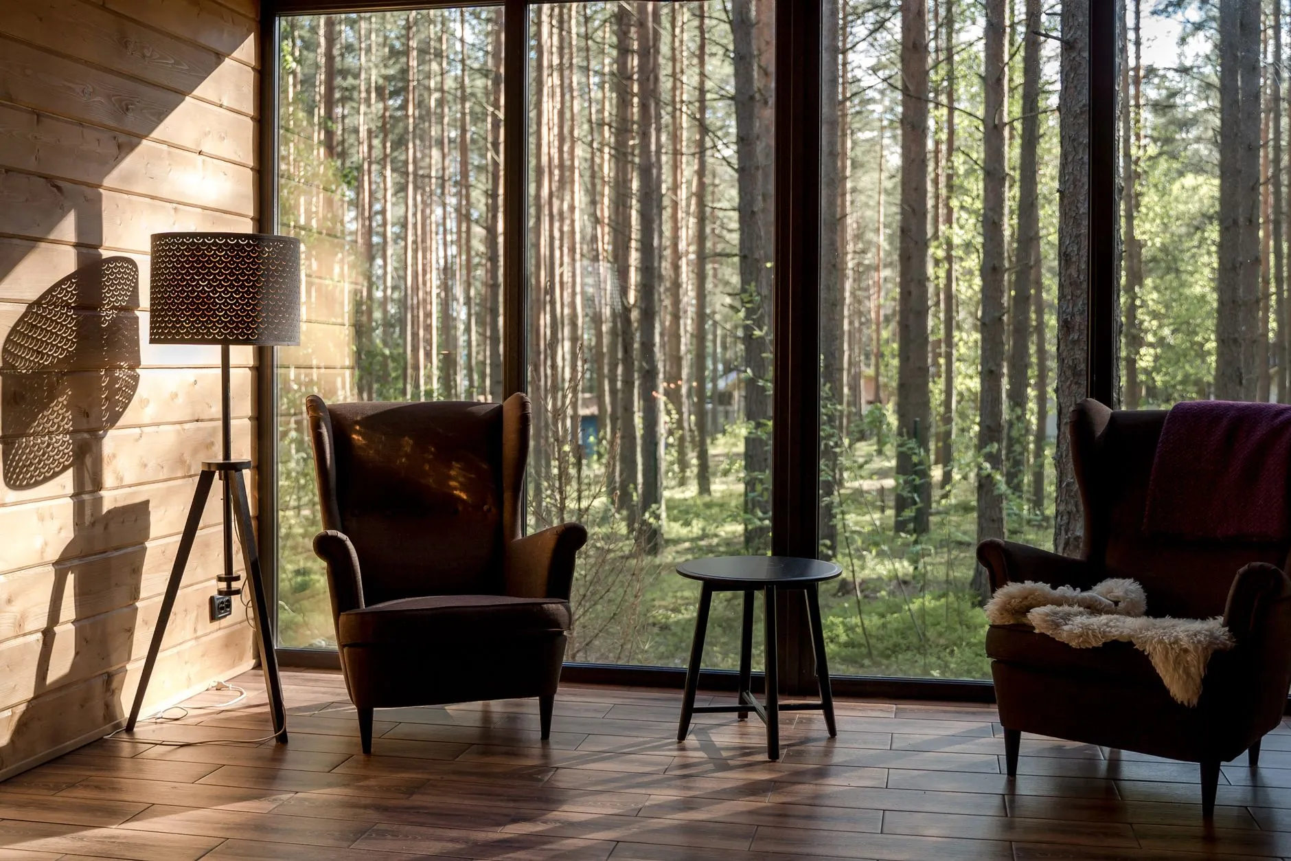 a warm room with two armchairs facing a large window