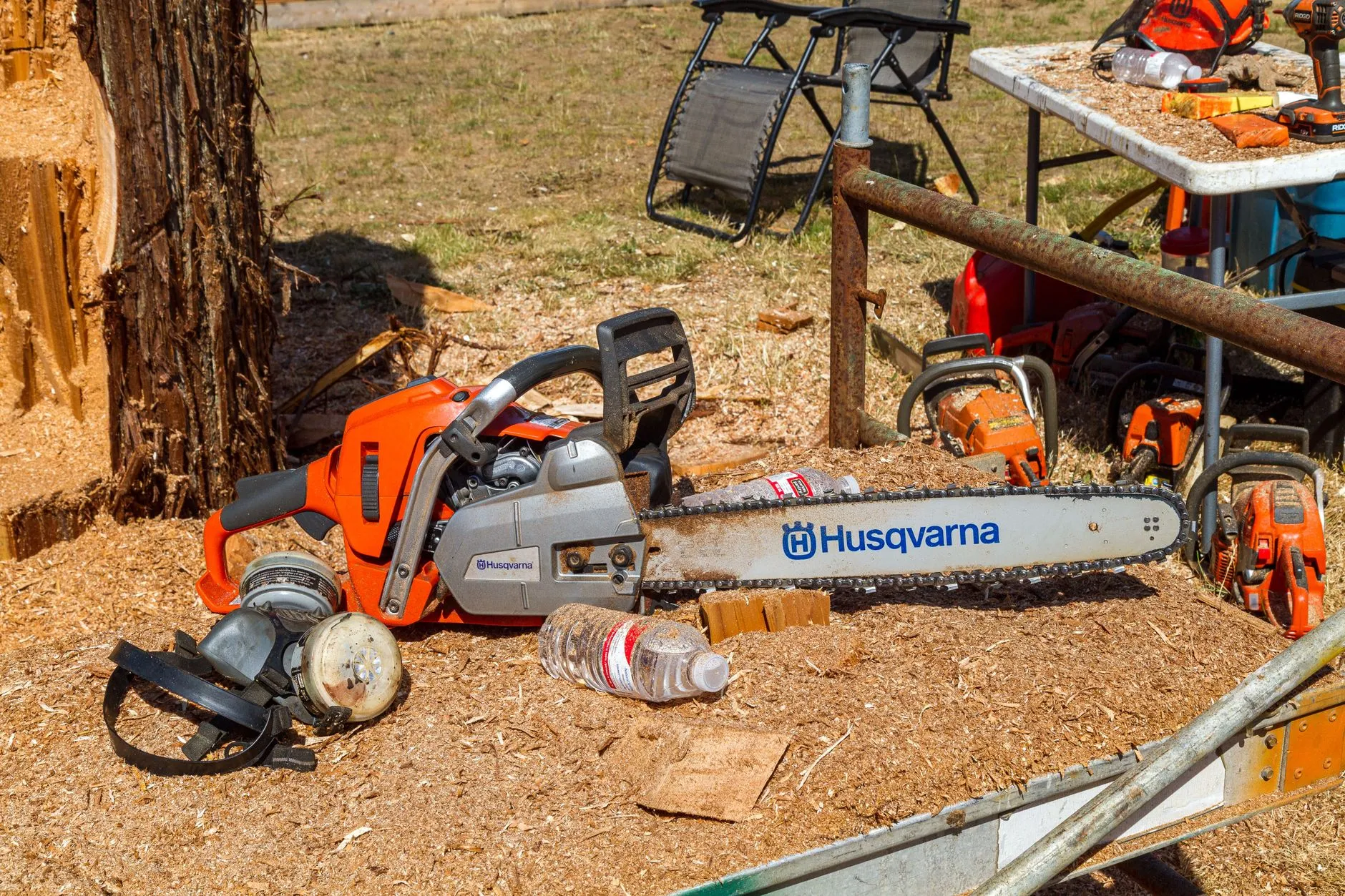 chainsaws and grinding equipment laid out on the ground