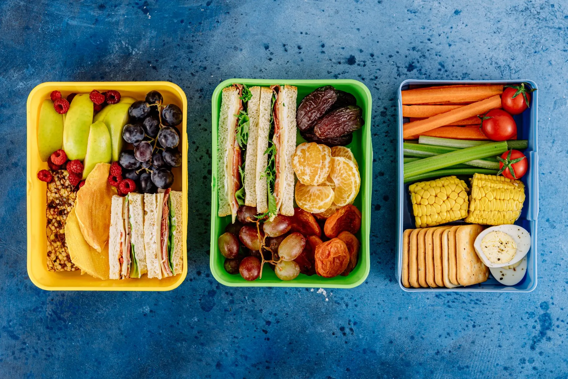 packed school lunch boxes with sandwiches, fruit and vegetables