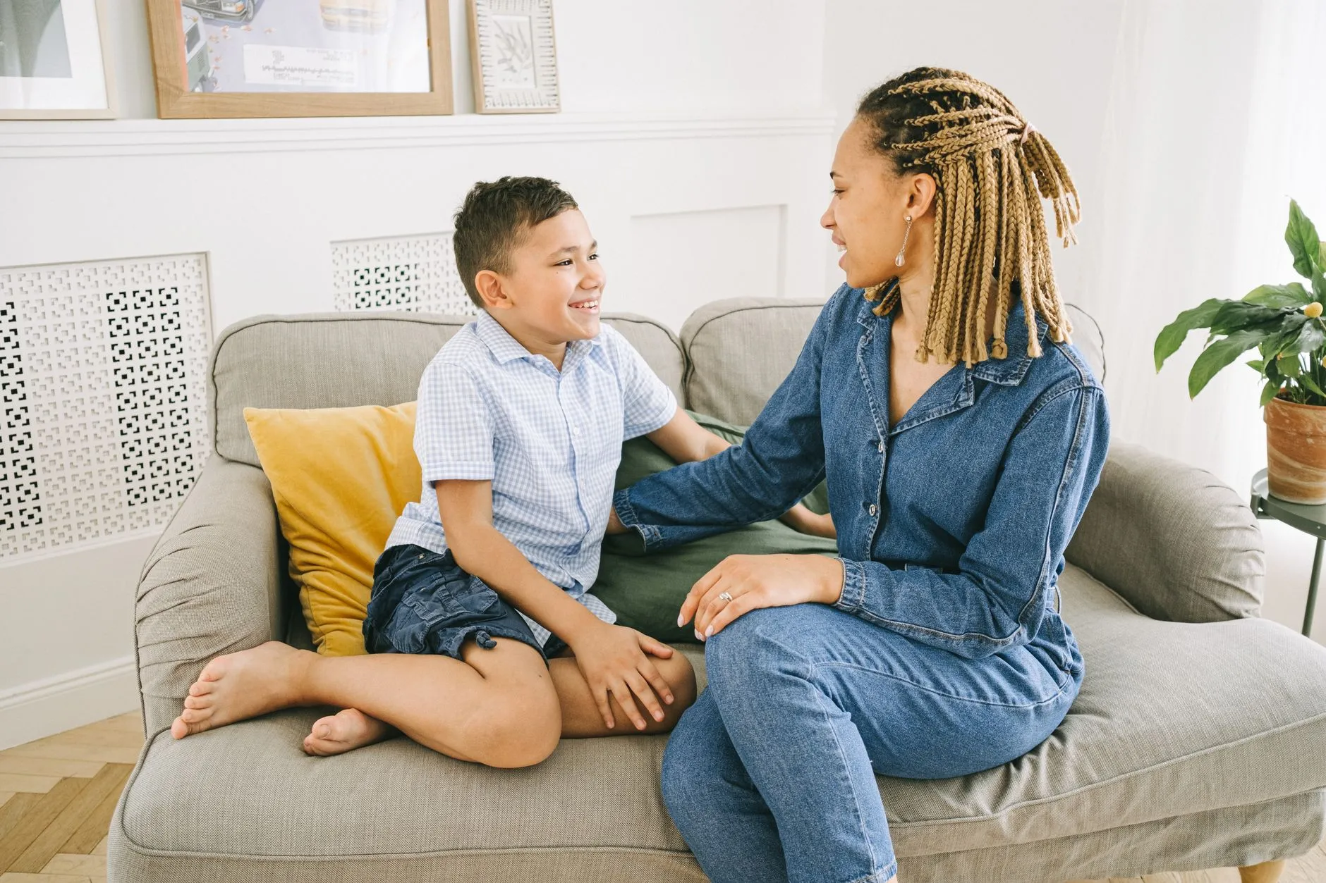 a mother and her son talking on a sofa