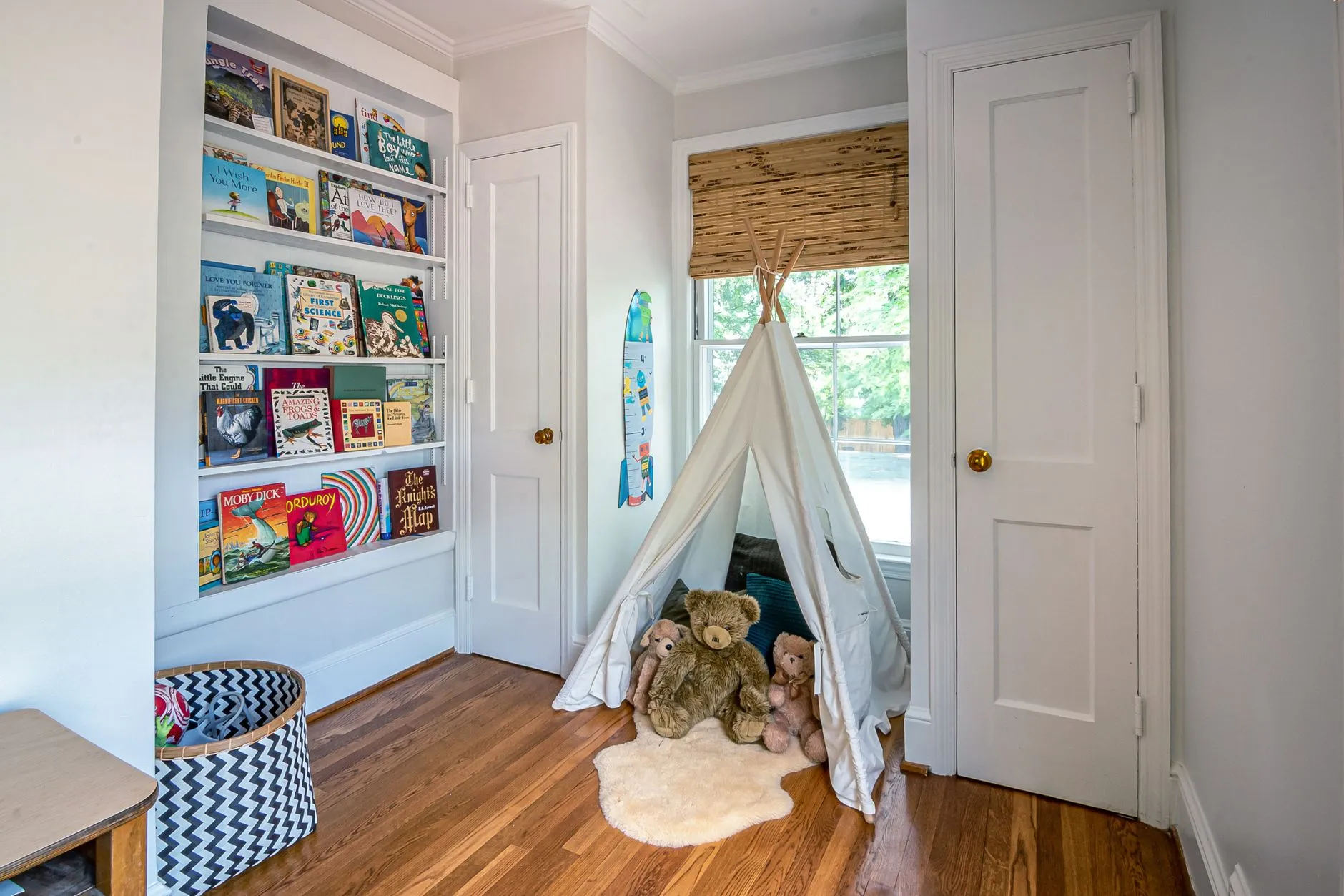 a reading nook with a small tent and shelves of children's books