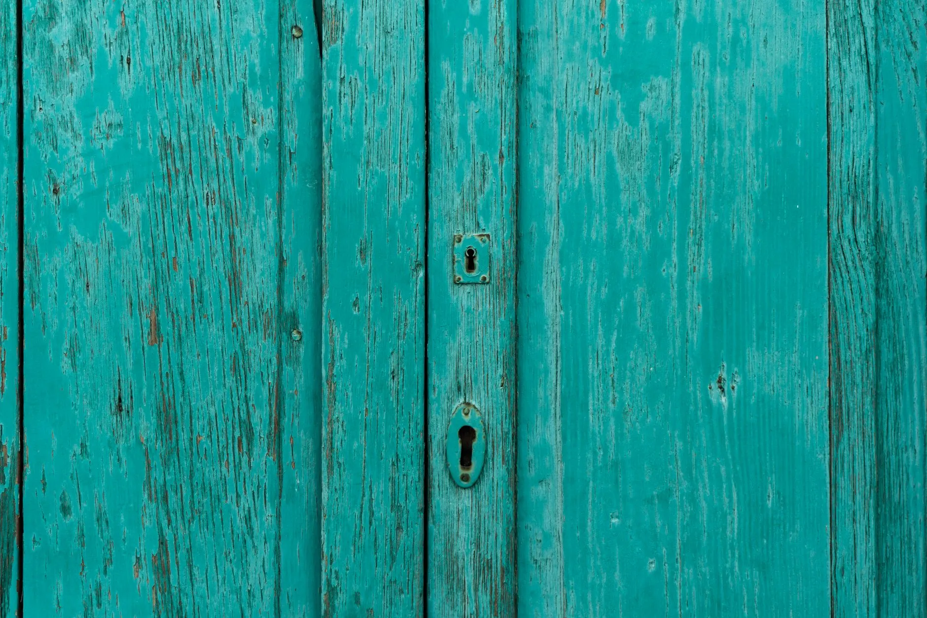 a weathered turquoise wooden door