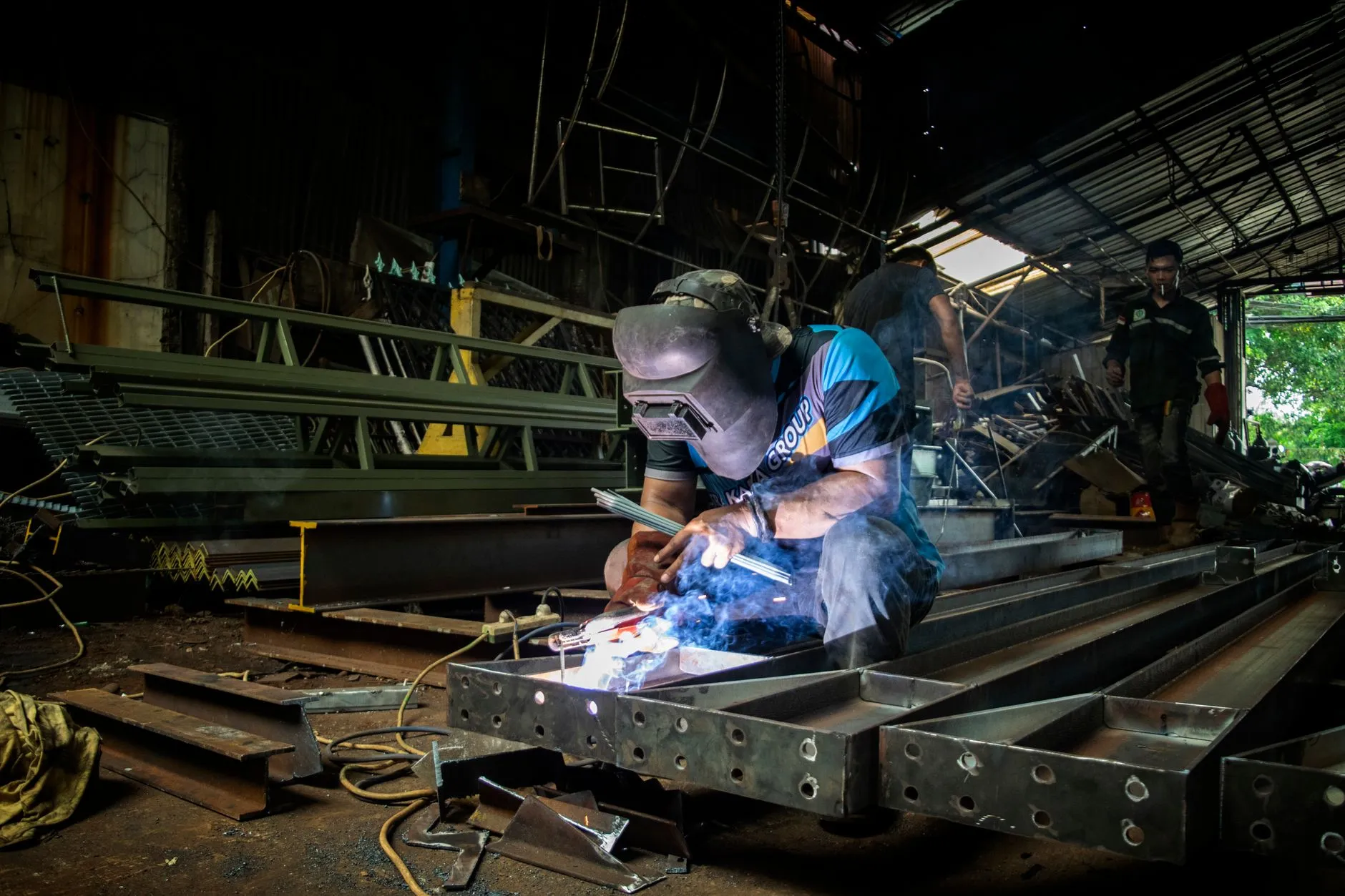 a fabricator welding steel components in a workshop