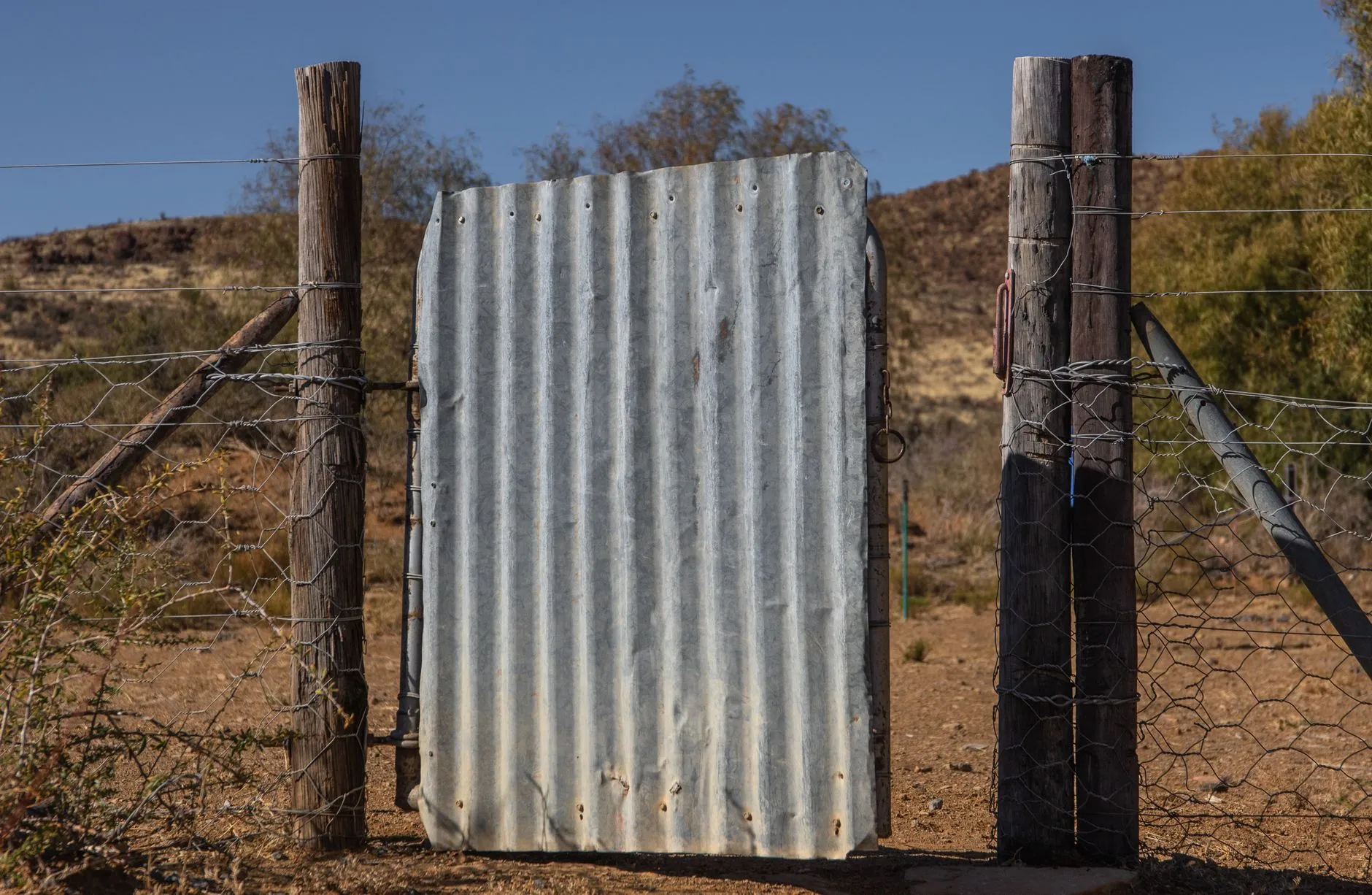 a corrugated metal gate in a fence line