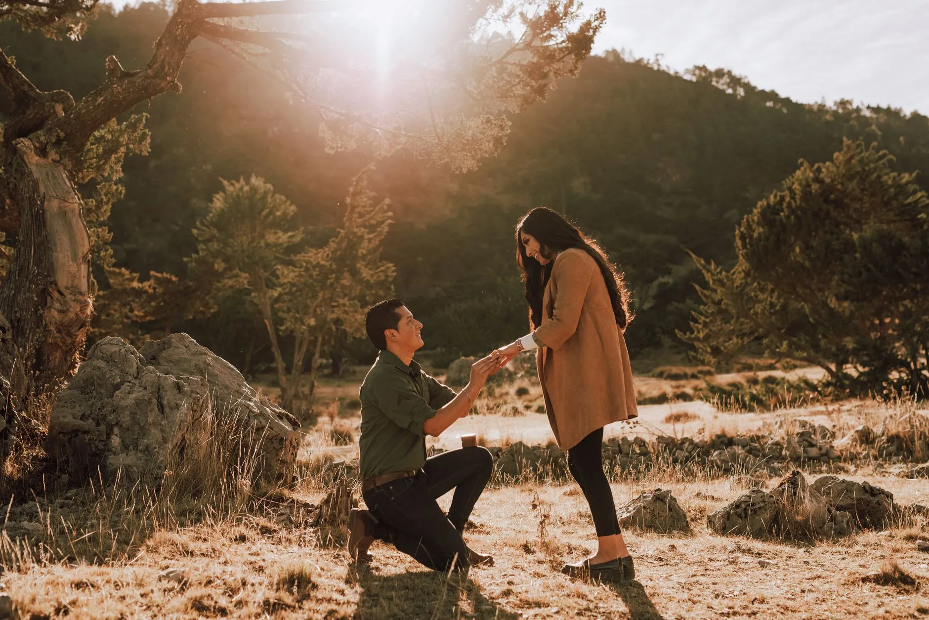 a couple embracing after a marriage proposal on a scenic overlook