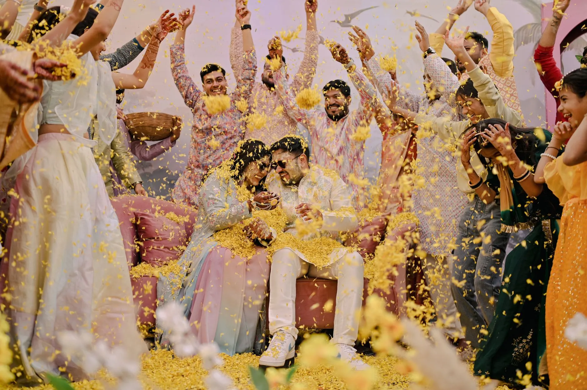 joyful Indian wedding couple showered with flower petals during a ceremony