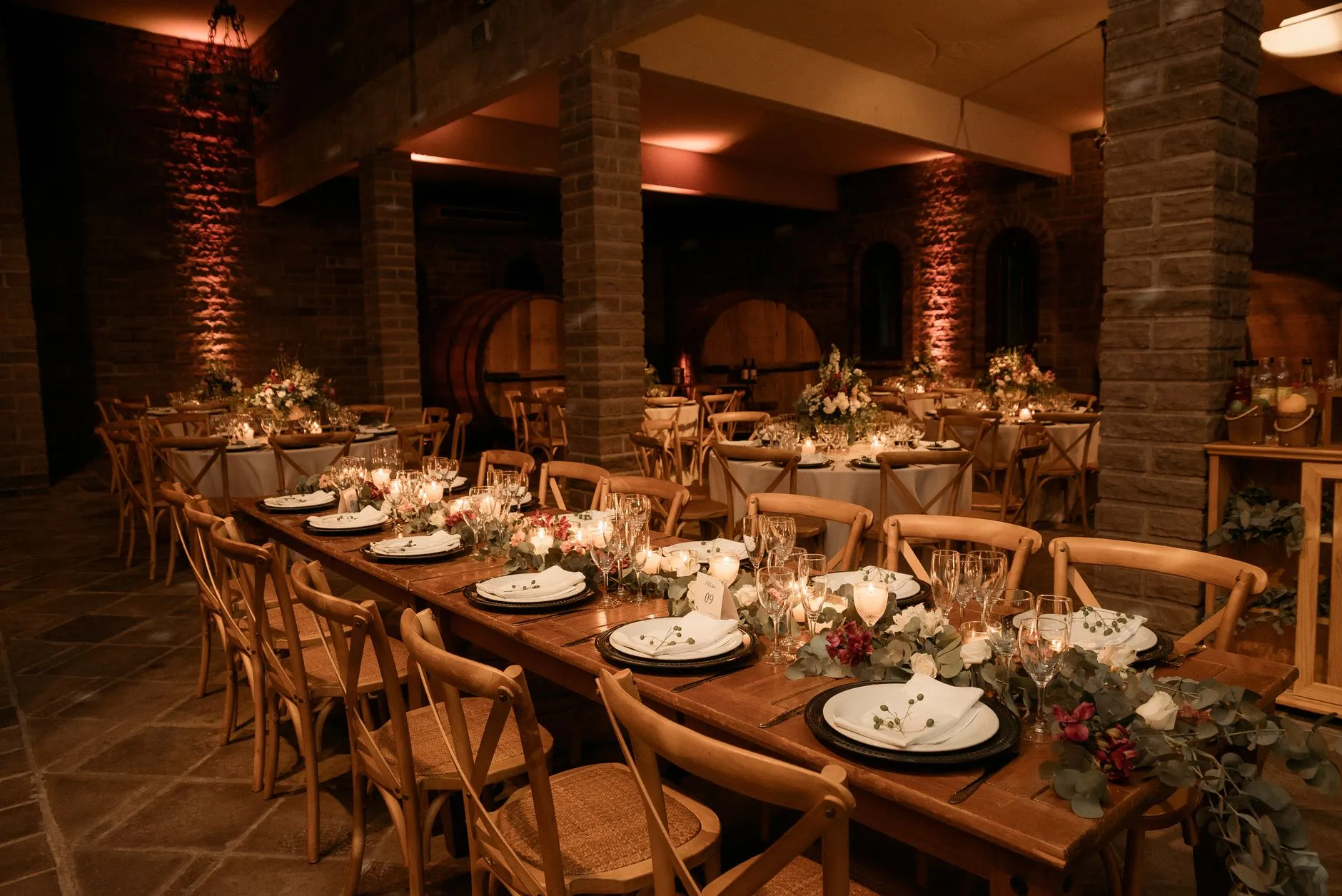 elegant winery barrel room set for a wedding reception with warm lighting