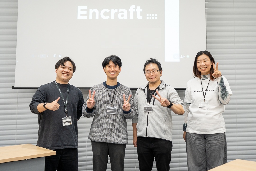 パネリスト・モデレーターの4人がスクリーンの前で笑顔で並んでいます。