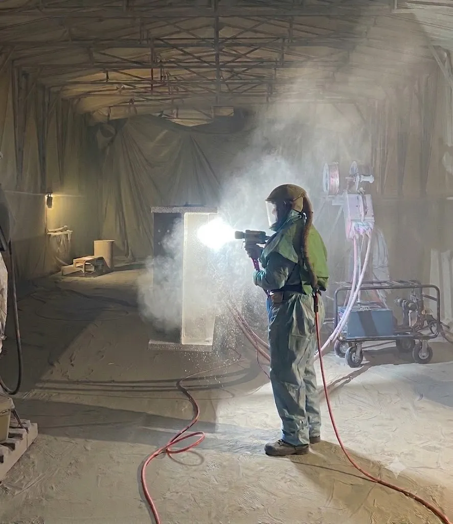 Worker applying thermal spray coating