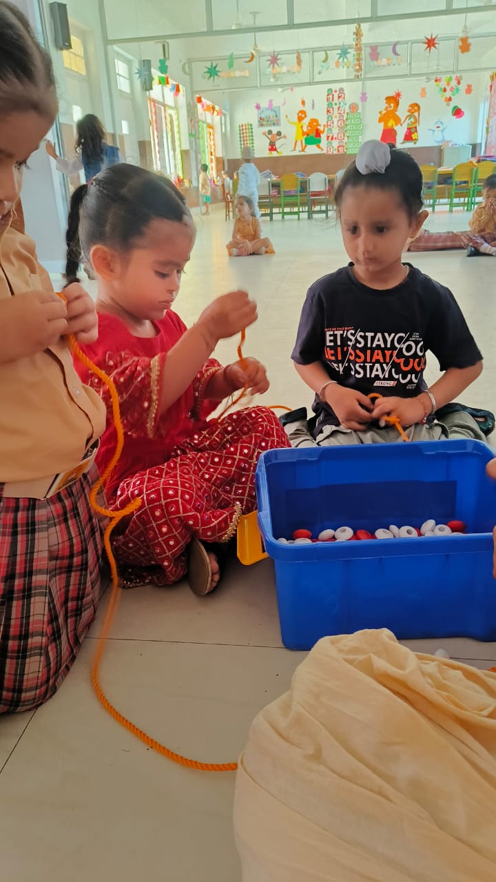 Activity is sorting the white beads and stringing in rope