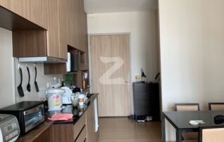 The kitchen and the dinning table for 4 person. The kitchen is composed of microwave, electrical stove and hood. This view is taken from living area.